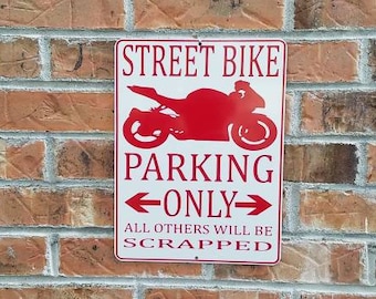 May include: Red and white sign with the text "Street Bike Parking Only" and an arrow pointing left and right. The sign also says "All others will be scrapped".