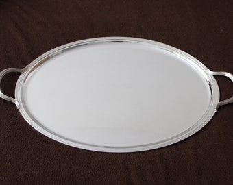 May include: A silver oval serving tray with two handles. The tray is empty and has a shiny surface.
