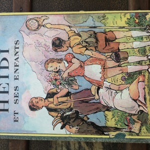 Może przedstawiać: Okładka starej książki z kolorową ilustracją dzieci na polu. Tytuł książki to "HEIDI ET SES ENFANTS" na ż&oacute;łtym tle.