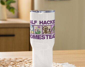 May include: A white insulated travel mug with a lid, displaying the text "Half Hacke Homestead" in purple. The design includes illustrations of a chicken, flowers, a spinning wheel, and beans.