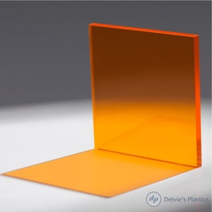 May include: A bright orange acrylic sheet, standing upright on a white surface. The sheet is translucent and has a slight sheen.