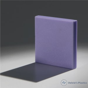 May include: A rectangular, lavender-colored plastic block with a textured surface. The block casts a dark shadow on a light surface. The corner of the block is slightly rounded. The logo for Delvie's Plastics is in the lower right corner.