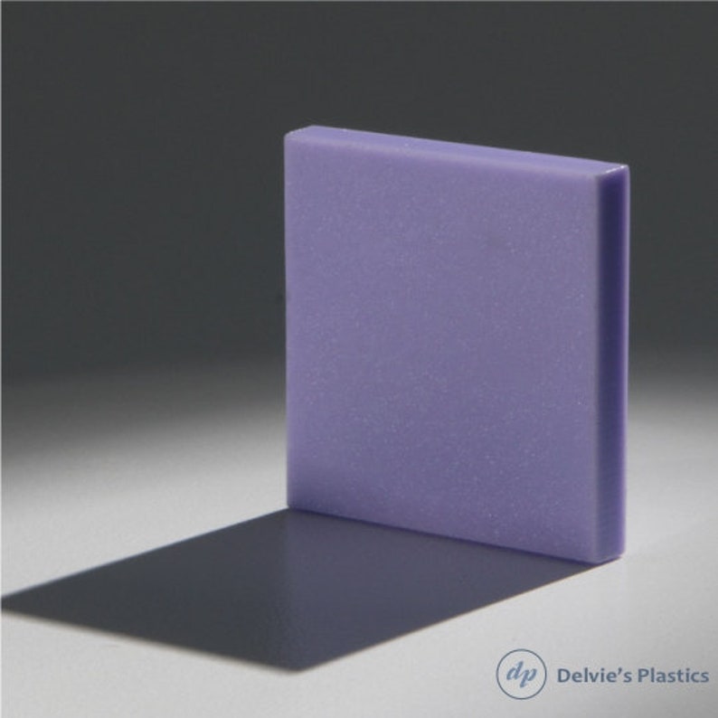 May include: A rectangular, lavender-colored plastic block with a textured surface. The block casts a dark shadow on a light surface. The corner of the block is slightly rounded. The logo for Delvie's Plastics is in the lower right corner.