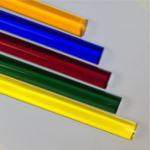 May include: Five glass rods in different colors: yellow, blue, red, green, and yellow. The rods are arranged in a staggered pattern, with the yellow rod at the top and the yellow rod at the bottom.