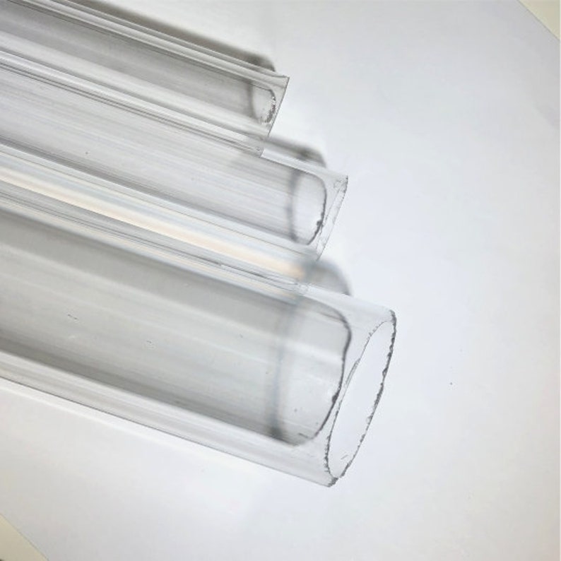 May include: Three clear acrylic tubes of varying sizes, stacked on top of each other. The tubes are smooth and have a slightly frosted appearance.