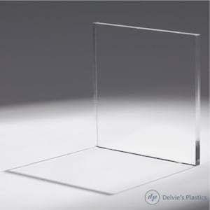 May include: A clear acrylic sheet, standing upright on a white surface. The sheet is smooth and transparent, with a slight sheen.
