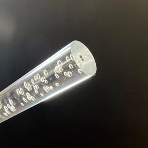May include: A clear acrylic rod with small air bubbles throughout. The rod is about 1/2 inch in diameter.
