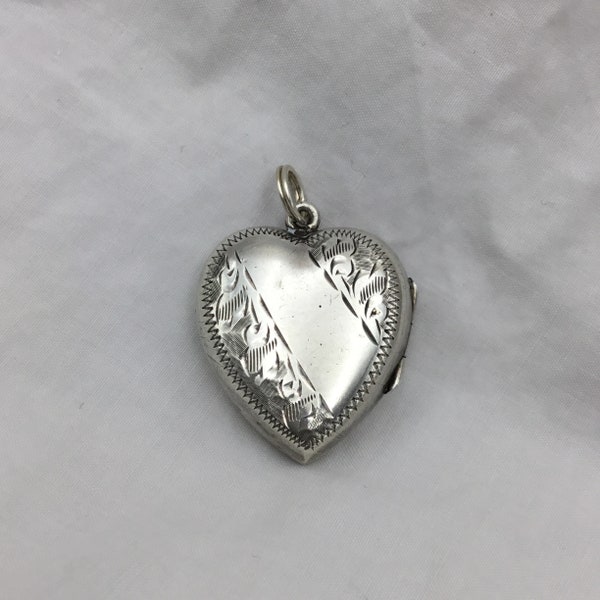 Vintage 1940s to 1950s Silver heart locket pendant. Good condition. Weight 5.4g. Size 2.7cm x 2.2cm x 7mm thick. Small to medium size.