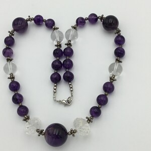 May include: A purple amethyst and clear crystal beaded necklace with a large amethyst pendant.