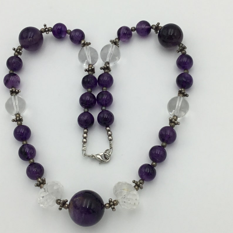 May include: A purple amethyst and clear crystal beaded necklace with a large amethyst pendant.