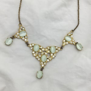 Collar vintage Hollywood firmado con piedras de cristal opalino con bandas blancas y diamantes de imitación transparentes, cadena de latón dorado. Mediados de siglo, década de 1960.