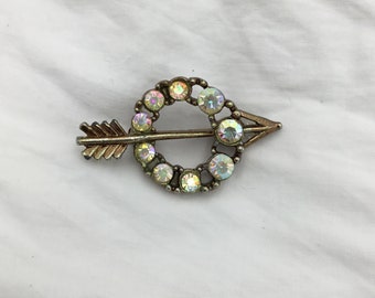 Vintage Aurora Borealis (slightly rainbow) rhinestone circle arrow gold tone small brooch. Vintage 1950s to 1960s. Size 4cm x 2.2cm widest