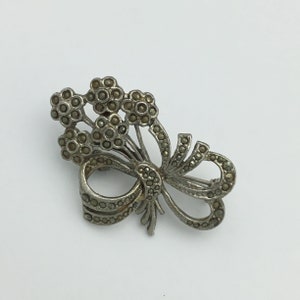 Vintage marcasite flower cluster bouquet bow ribbon silver tone 1950s brooch in good condition. Size 4.5cm x 3.2cm. Stones complete.