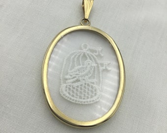 White lace bird in birdcage inside glass and gold tone pendant. Large size oval 4.6cm x 3.5cm. Unusual.