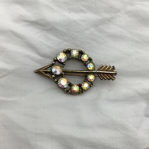 Petite broche vintage aurore boréale légèrement arc-en-ciel en forme de cercle avec flèche en strass, ton doré. vintage des années 50 à 60. Taille 4 cm x 2,2 cm au plus large image 9