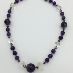 May include: A purple amethyst and clear crystal beaded necklace with a large amethyst pendant.