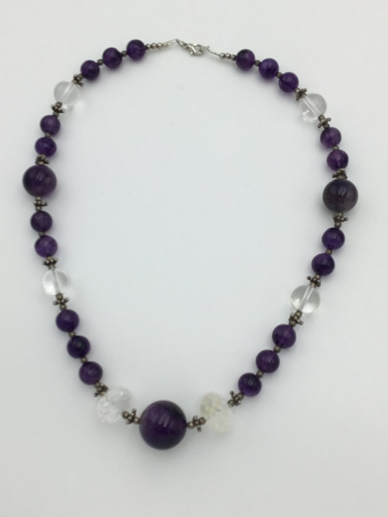 May include: A purple amethyst and clear crystal beaded necklace with a large amethyst pendant.