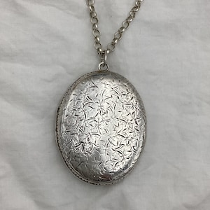 Collar vintage de plata de ley con medallón ovalado de hojas y flores. Tamaño mediano-grande (5 cm). Estilo victoriano, pero de la década de 1980. Cadena de 66 cm (26 pulgadas). 26,7 g