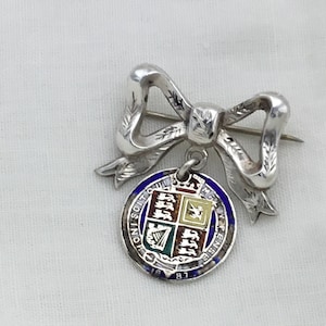 Antique Victorian silver 1887 green, blue, yellow and red enamel coin on sterling silver ribbon bow brooch. Queen Victoria Golden jubilee