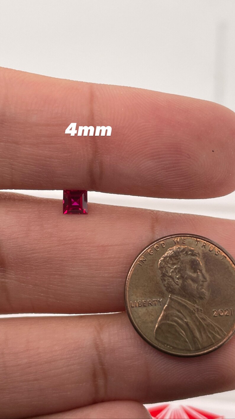 May include: A 4mm square-shaped ruby gemstone, shown next to a US penny for size comparison.
