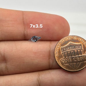Peut inclure: Une pierre pr&eacute;cieuse transparente et facet&eacute;e mesurant 7 mm x 3,5 mm, tenue dans une main &agrave; c&ocirc;t&eacute; d'une pi&egrave;ce de un centime d'euro pour comparaison de taille.