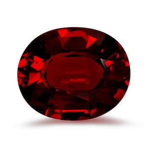 May include: A deep red oval gemstone with a faceted cut. The gemstone is set against a white background.