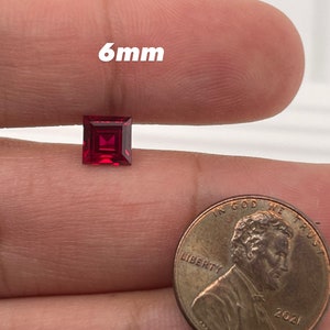 May include: A 6mm square-shaped ruby gemstone, shown next to a US penny for size comparison.