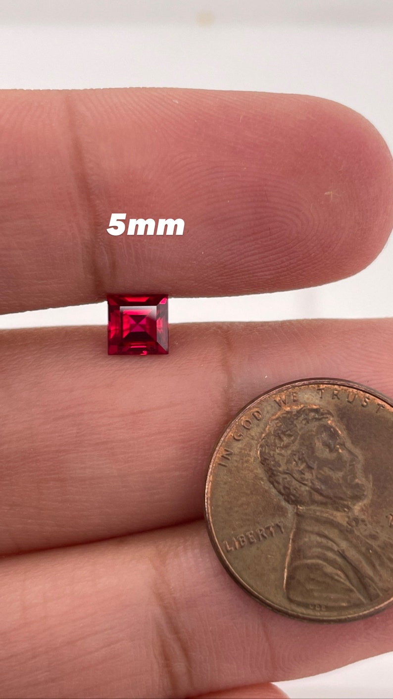 May include: A 5mm square red gemstone, shown next to a US penny for size comparison.