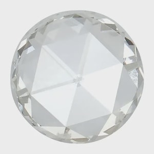 May include: A clear, faceted crystal sphere. The sphere is round with multiple flat, triangular surfaces that reflect light. The crystal appears to be made of glass or a similar transparent material, and it sits against a plain, light background.