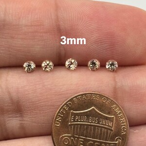 May include: Five small, round, light-colored gemstones, each approximately 3mm in diameter, are displayed next to a United States one-cent coin. The text "3mm" is visible above the gemstones.