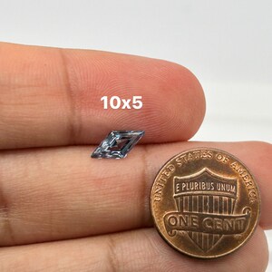 Peut inclure: Une pierre pr&eacute;cieuse bleu clair de forme carr&eacute;e, mesurant 10x5 millim&egrave;tres, est pr&eacute;sent&eacute;e &agrave; c&ocirc;t&eacute; d'un penny am&eacute;ricain pour comparaison de taille.