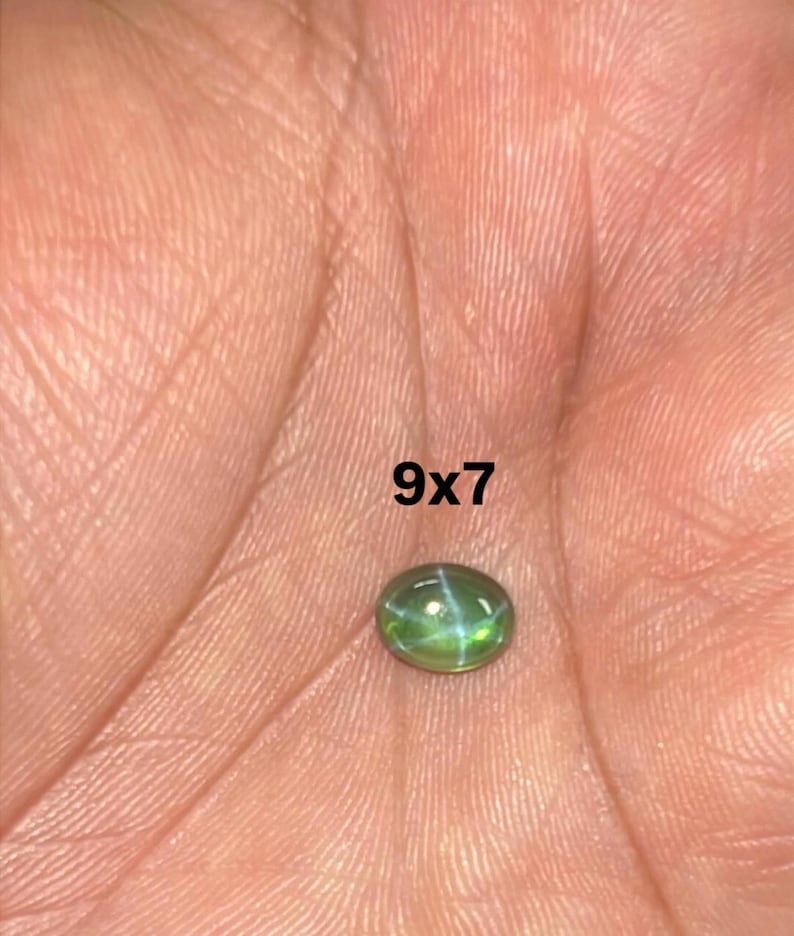 May include: A green oval gemstone with a star-like pattern inside. The gemstone is 9x7 mm.