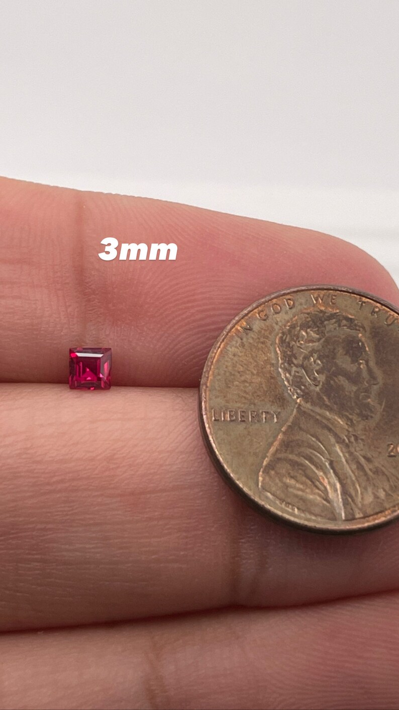 May include: A 3mm square-shaped ruby gemstone, shown next to a US penny for size comparison.
