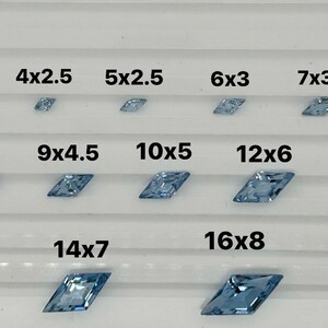Peut inclure: Comparaison de diff&eacute;rentes tailles de pierres pr&eacute;cieuses facett&eacute;es bleu clair, allant de 4x2 pouces &agrave; 16x8 pouces. Un centime am&eacute;ricain est inclus pour l'&eacute;chelle.