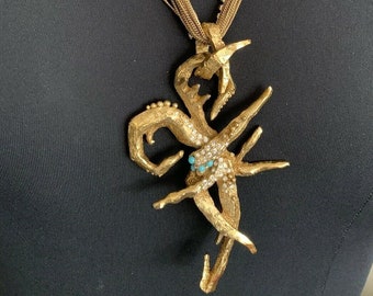 May include: A gold tone necklace with a multi-strand chain and a large scorpion pendant with turquoise accents.