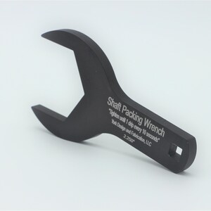 May include: A black metal wrench with the text "Shaft Packing Wrench" and "Tighten until 1 drip every 10 seconds" engraved on the handle. The wrench is designed for use with shaft packing.