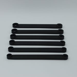 May include: Six black plastic connectors with rounded ends and square holes. The connectors are arranged in a vertical stack.