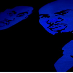 May include: A high-contrast graphic print featuring two stylized faces in vibrant blue against a solid black background. The illustration highlights facial features with bold lines, capturing the expressions of two individuals in a monochromatic blue tone.