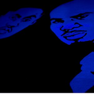 May include: A high-contrast graphic print featuring two stylized faces in vibrant blue against a solid black background. The illustration highlights facial features with bold lines, capturing the expressions of two individuals in a monochromatic blue tone.