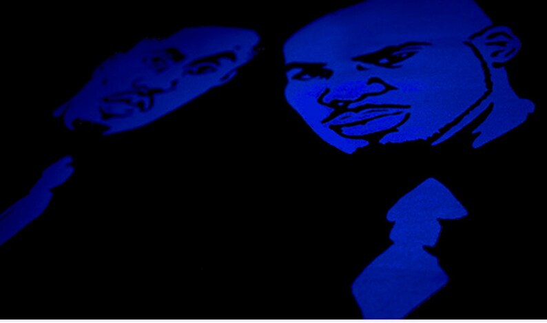 May include: A high-contrast graphic print featuring two stylized faces in vibrant blue against a solid black background. The illustration highlights facial features with bold lines, capturing the expressions of two individuals in a monochromatic blue tone.