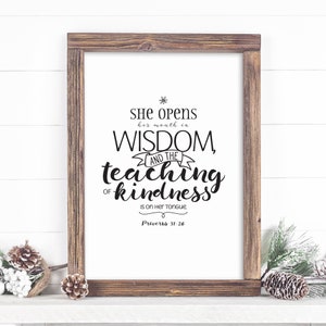 May include: A framed print with a white background and black text. The text reads "She opens her mouth in wisdom, and the teaching of kindness is on her tongue. Proverbs 31:26".