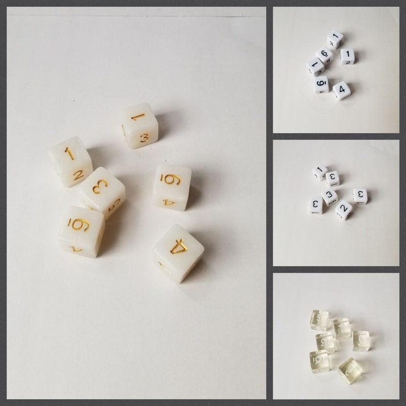 May include: A collection of white dice with gold numbers. The dice are scattered on a white surface. Some dice have black numbers.