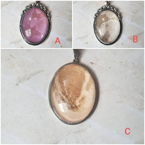 May include: Three silver oval pendants with different colored resin inserts. The inserts feature a snakeskin pattern. The pendants are labeled A, B, and C.