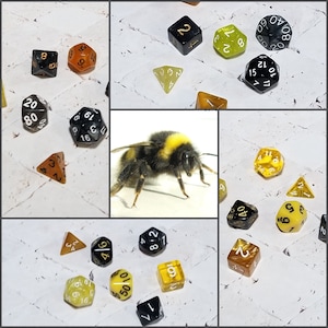 May include: A collage of images featuring a bumblebee, dice, and a white background. The dice are various colors, including black, yellow, and orange. Some of the dice have numbers on them, while others have symbols. The bumblebee is in focus and is sitting on a white surface.