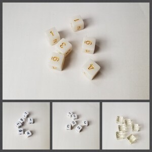 May include: A collection of white dice with gold numbers, and a collection of white dice with black numbers, and a collection of clear dice with black numbers.