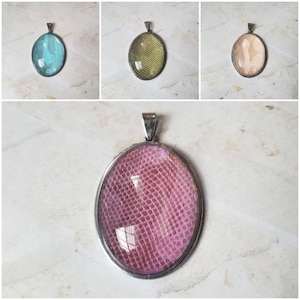 May include: A silver pendant with a pink oval-shaped resin insert featuring a snakeskin pattern.