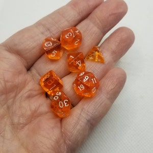 May include: A set of orange dice with white numbers. The dice are a d4, d6, d8, d10, d12, and d20.