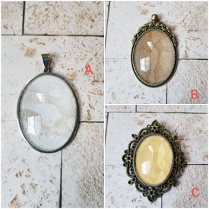 May include: Three oval-shaped glass pendants with different frames. The first pendant has a simple silver frame. The second pendant has a gold-toned frame with a decorative design. The third pendant has a more elaborate gold-toned frame with a floral design.