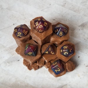 May include: A brown, multi-sided, 3D printed dice tower with six iridescent dice. The dice have gold numbers and are scattered throughout the tower.