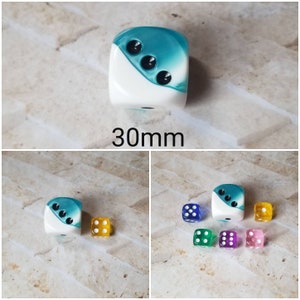 Op de afbeelding: Een set van 10 dobbelstenen, waaronder een grote 30 mm teal en witte dobbelsteen met zwarte stippen, en negen kleinere dobbelstenen in verschillende kleuren. De dobbelstenen zijn allemaal polyhedrisch en hebben een verschillend aantal zijden.